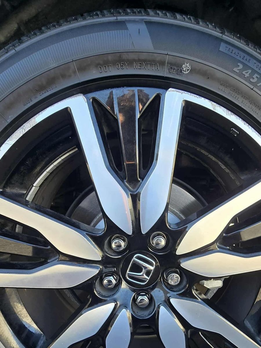 Two-tone Honda wheel with a scuffed lip, before repair